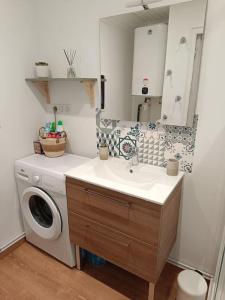 a bathroom with a sink and a washing machine at Charmant Chalet de montagne in Picherande