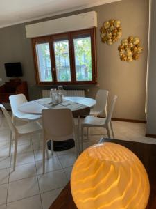 a dining room with a white table and chairs at La Bomboniera in Cervia