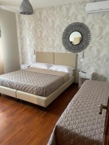 a bedroom with two beds and a mirror on the wall at La Bomboniera in Cervia