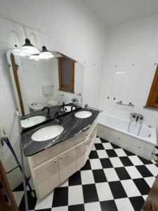 a bathroom with two sinks and a black and white checkered floor at La Bomboniera in Cervia +13 photos