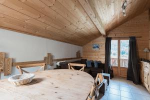 a dining room with a wooden table and a couch at Appartement Orion à Saint Gervais, proche Chamonix in Saint-Gervais-les-Bains