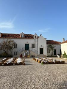 Casais da CarneiriaにあるSantuário SOS Animalの中庭に干し草の俵が置かれた大きな白い建物