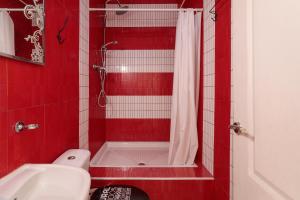 ein rotes Badezimmer mit einer weißen Dusche und einem Waschbecken in der Unterkunft La torre in Alicante + 12 Fotos