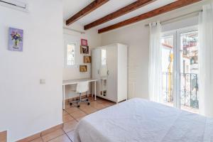 ein weißes Schlafzimmer mit einem Bett und einem Fenster in der Unterkunft La torre in Alicante