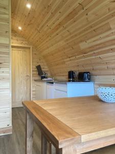a kitchen with a wooden ceiling and a wooden table at The Bell Inn in Wendens Ambo
