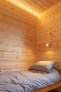 a bed in a room with a wooden wall at The Bell Inn in Wendens Ambo +8 photos