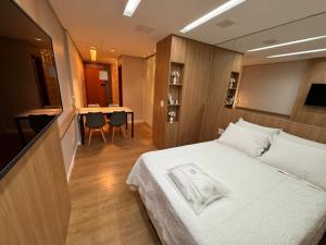 a bedroom with a bed and a table with chairs at Flat Sudoeste Ed. Leonardo Center by CentoEdez in Brasília +19 photos