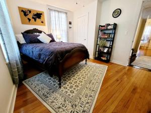 ein Schlafzimmer mit einem Bett und einem Teppich auf einem Holzboden in der Unterkunft Apple Hill Bungalow, Family and PET Friendly! in Bristol