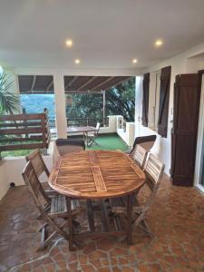 a wooden table and chairs in a room at A Casa Radica, appartement rez-de-villa au calme, jardin et maquis in Eccica-Suarella