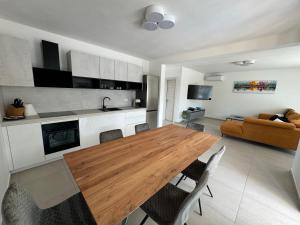 a kitchen and living room with a wooden table and chairs at Villa Mario in Poreč
