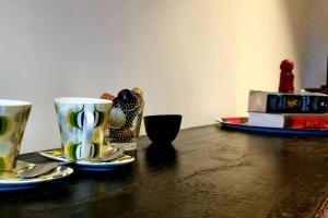 a table with two coffee cups and spoons on it at Garden room in green surroundings, sleeps 2 in Roeselare