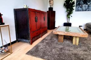 a living room with a red cabinet and a coffee table at Garden room in green surroundings, sleeps 2 in Roeselare