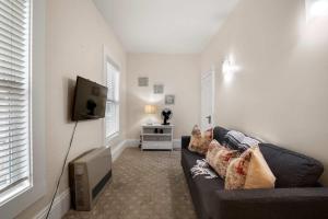 a living room with a couch and a tv at Cozy Retreat on Commercial Street for 2 in Provincetown