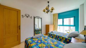 a bedroom with two beds and a mirror at Piso Atrium de 1 dormitorio in Villajoyosa