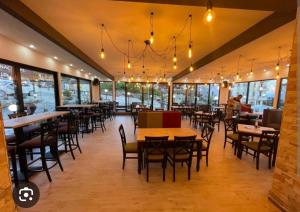 a restaurant with tables and chairs and windows at Milmari resort N12 in Kopaonik