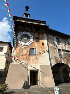a building with a clock on the side of it at Monolocale All'orologio in Clusone