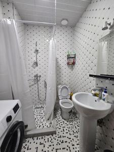 Un baño con ducha, inodoro y lavabo. en Квартира, en Batumi