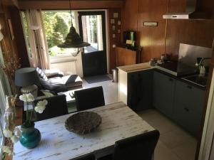 a kitchen and living room with a table and a kitchen and a dining room at Wendrik Hoeve Bed & Stables in Emst