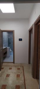 an empty room with a white wall and a bathroom at Odysea in Comiso