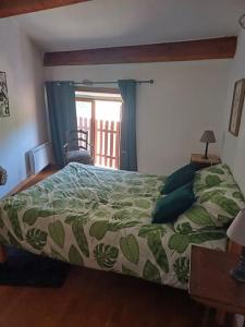 a bedroom with a bed with a green comforter at Duplex 85m2 au coeur de la nature à Montpezat-sous-Bauzon in Montpezat-sous-Bauzon