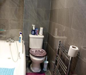 a bathroom with a toilet and a bath tub at Spacious 4-Bed House - Sleeps 5 Garden & Parking in London +20 photos