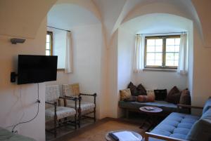 a living room with a couch and a tv at Schloss Hofstetten Ingerle-Klause in Hofstetten