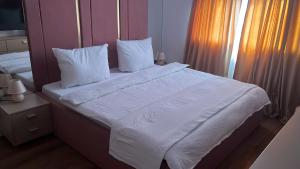 a bedroom with a large bed with white sheets and pillows at Apartament Giroc in Fratelia