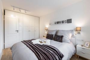 a bedroom with a white bed with a dog on it at Weissach Apartments in Kreuth