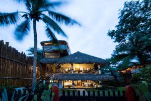 a building with a palm tree in front of it at Casa Marco in Puerto Escondido +25 photos