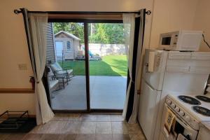 a kitchen with a door to a patio with a microwave at Peaceful Apartment in Traverse City