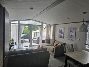 a living room with a couch and a table at Mawgan Pads Padstow in Padstow