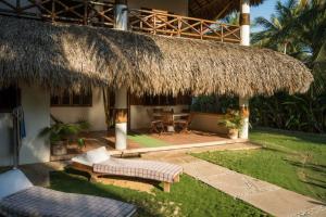 a house with a thatched roof and a patio at Casa Marco in Puerto Escondido