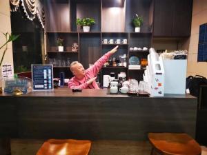 a man standing behind a counter with his arms up at Chengdu Sichuan University Budget Hotel in Chengdu +37 photos
