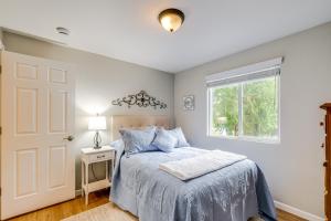 a bedroom with a bed with blue pillows and a window at Bremerton Home with Fire Pit Near Parks and Museums in Bremerton