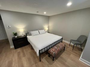a bedroom with a large bed and a chair at Aksarben Area 2 BD-2 BA by UNO in Omaha