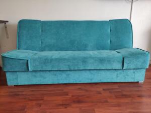 a blue couch sitting in a living room at Grand Studio avec piscine à Mandelieu in Mandelieu-la-Napoule +1 photo