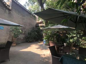 a patio with tables and chairs with umbrellas at Chengdu Sichuan University Budget Hotel in Chengdu
