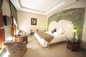 a bedroom with a large bed and a chair at Riad Flam & Spa in Marrakesh