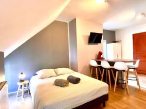 a bedroom with a bed and a table and chairs at La Belle Cuvée - Plein centre-ville Chablis in Chablis