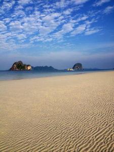 a sandy beach with two islands in the water at Thanya Beach Resort - SHA Plus in Ko Ngai
