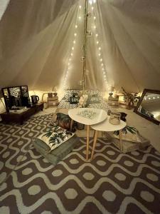a room with a tent with a table and pillows at LOVE ROOM Tente Lodge spa MFG chez C&C, exclusivement réservée aux ADULTES in Cantaron