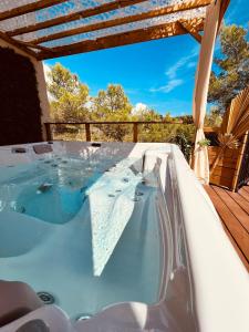 a jacuzzi tub on the deck of a house at LOVE ROOM Tente Lodge spa MFG chez C&C, exclusivement réservée aux ADULTES in Cantaron