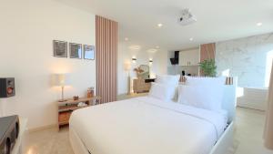 a white bedroom with a large white bed with white pillows at PS5, Cinéma & Jacuzzi - Skyline Luxe in Saint-Étienne