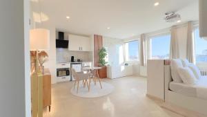 a white living room with a couch and a table at PS5, Cinéma & Jacuzzi - Skyline Luxe in Saint-Étienne