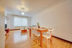 una sala da pranzo con un tavolo e sedie bianche di La Piscina de Cascajos by Clabao a Logroño