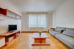 un soggiorno con un divano e una TV di La Piscina de Cascajos by Clabao a Logroño