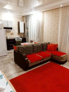 a living room with a couch and a red rug at VIP 2 Квартира-студия 1ком in Uralsk