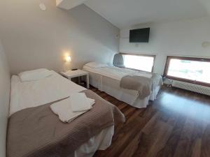 a hotel room with two beds and a tv at Rantakartano in Pori