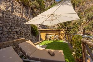 a patio with a table and an umbrella at Villa Nannina in Positano
