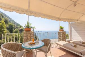 a patio with a table and chairs and a view of the ocean at Villa Nannina in Positano